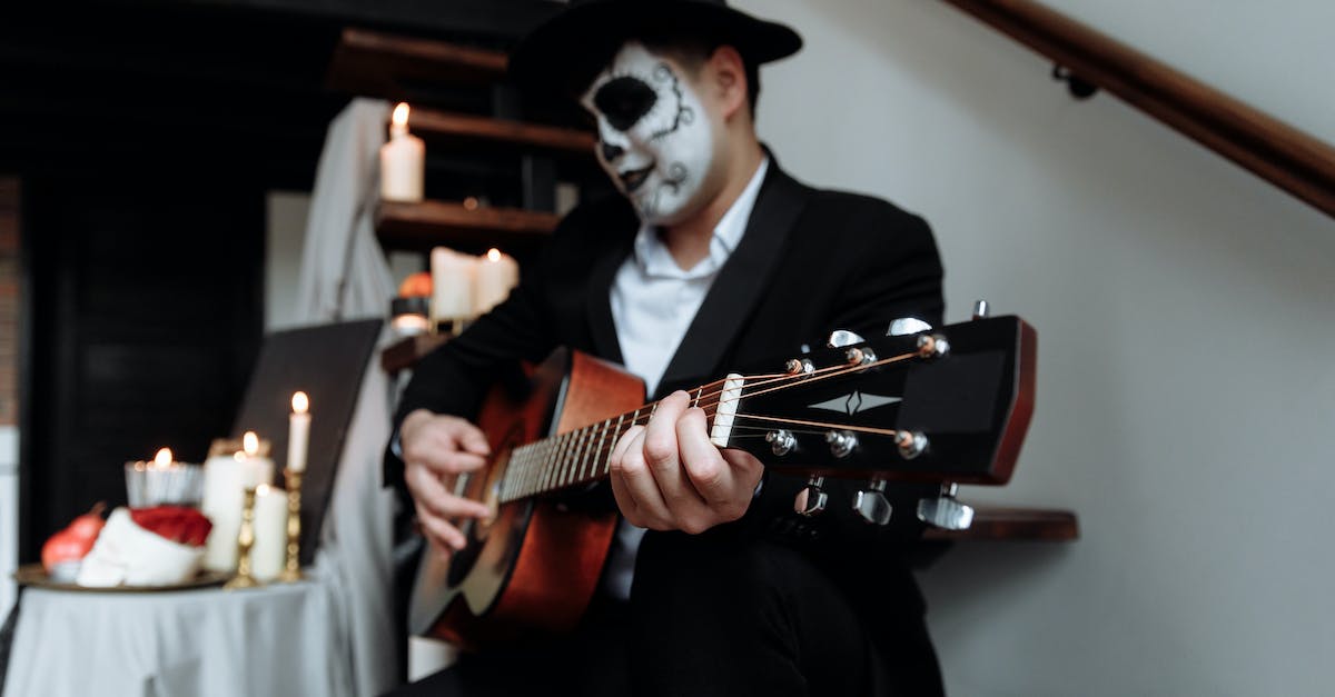 a-man-in-black-suit-playing-acoustic-guitar-5763665