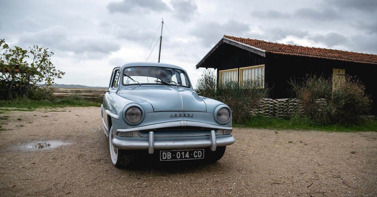 blue-mercedes-benz-coupe-parked-beside-brown-wooden-house-under-white-clouds-2123483
