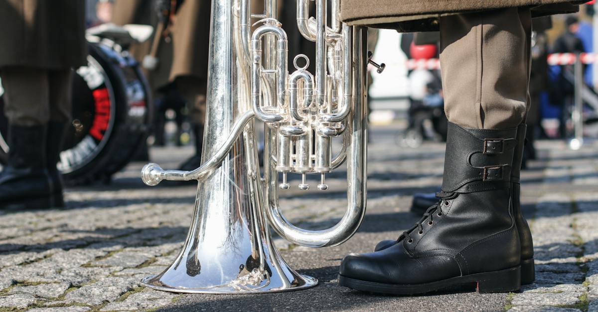 brass-trumpet-on-grey-concrete-floor-beside-a-person-wearing-black-leather-boots-2368952