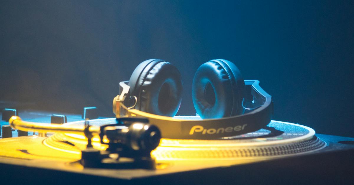 contemporary-headset-on-platter-disc-of-music-controller-with-knobs-and-faders-in-yellow-neon-light-3807772