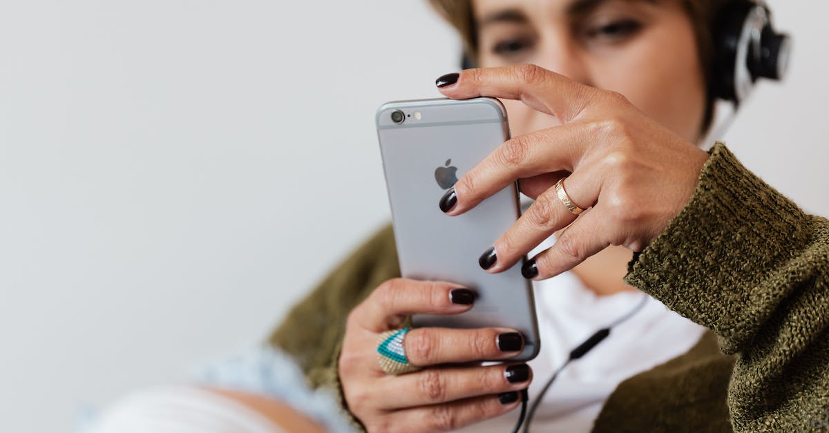 crop-blurred-focused-female-in-casual-warm-clothes-with-classy-ring-surfing-contemporary-cellphone-w-6922953