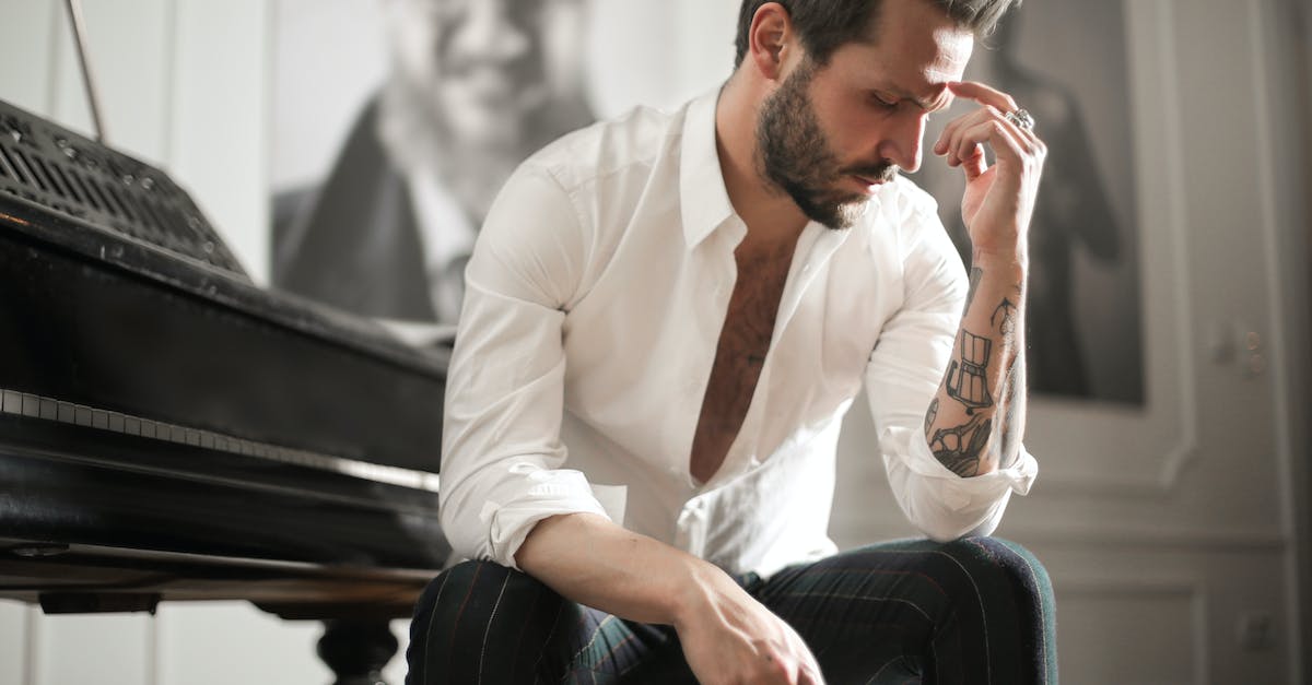 dramatic-tattooed-male-sitting-at-piano-3719628