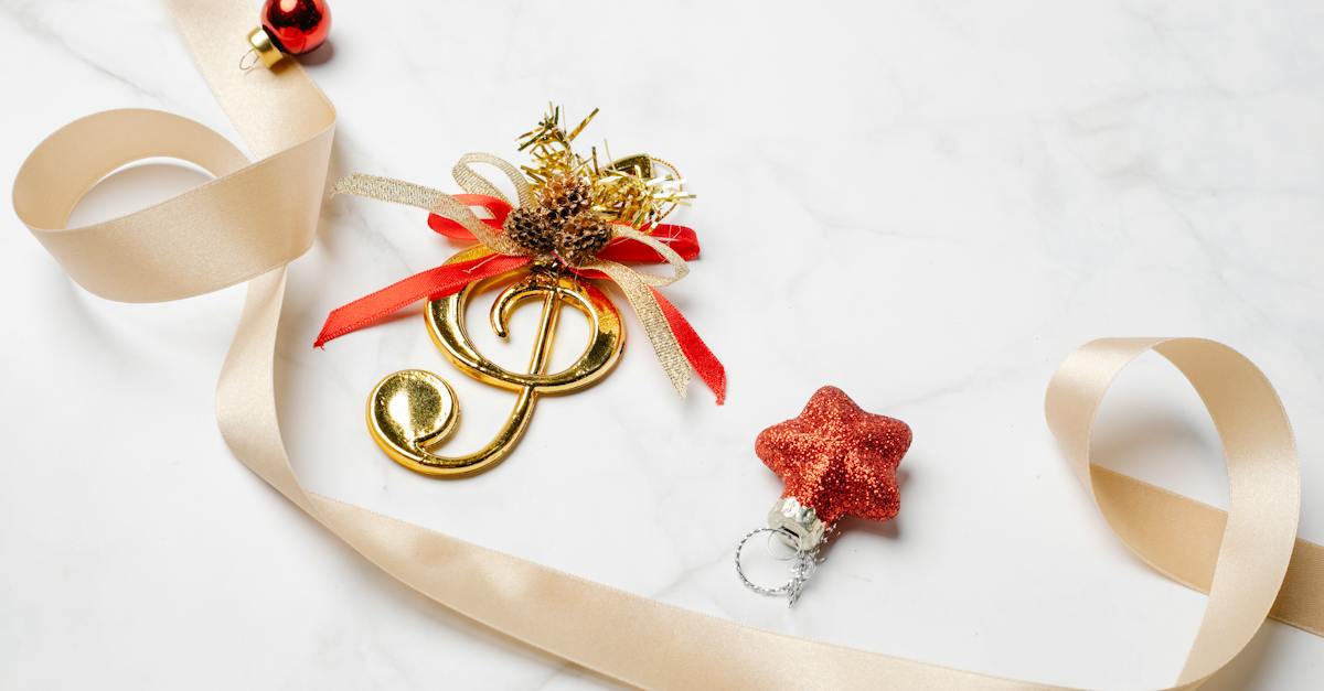 from-above-of-silky-ribbon-near-golden-musical-note-and-small-christmas-bauble-with-star-4130746