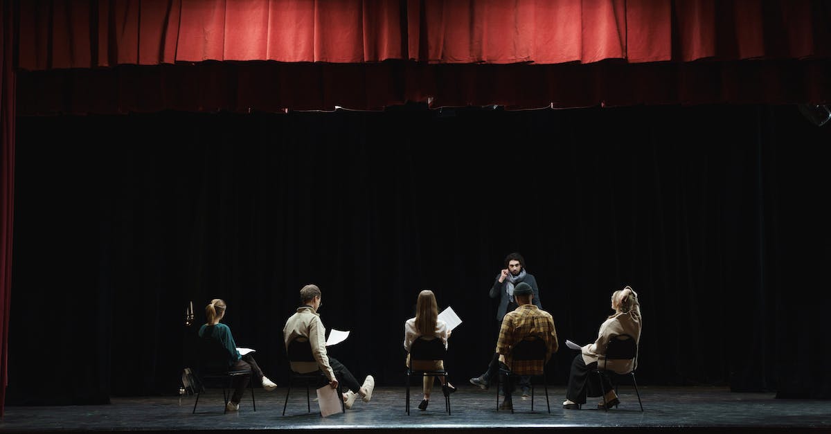 group-of-people-sitting-on-chair-on-stage-2545647