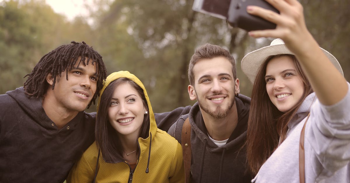 happy-diverse-friends-taking-selfie-in-park-7819603