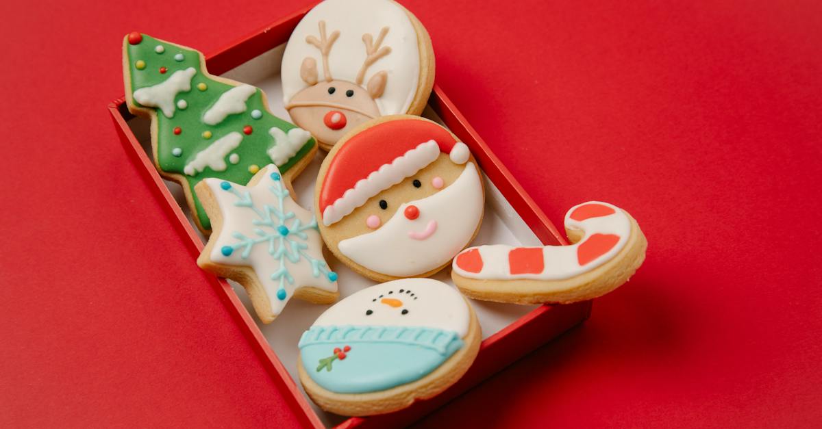 high-angle-of-small-box-with-traditional-christmas-biscuits-covered-with-colourful-icing-on-red-back-3665608