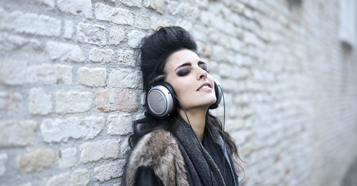 informal-young-woman-listening-to-music-near-grunge-wall-9597927