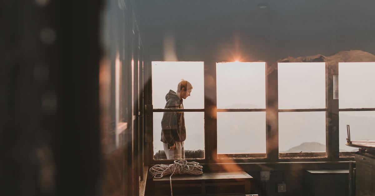 man-in-black-jacket-standing-on-window-6370139