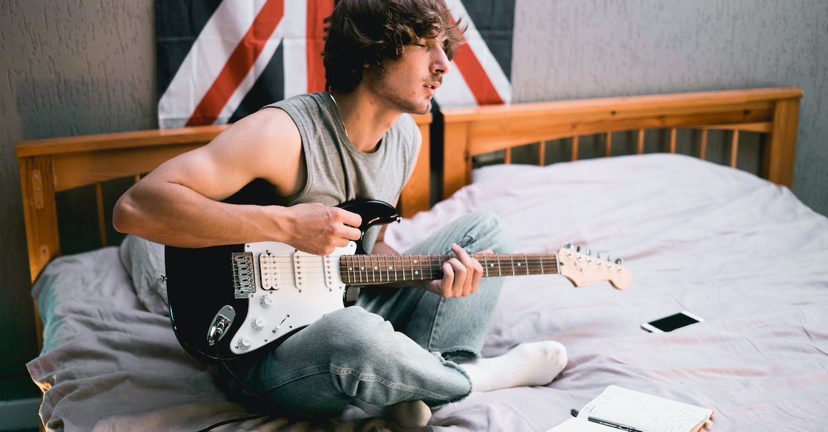 man-in-gray-tank-top-playing-electric-guitar-3698327