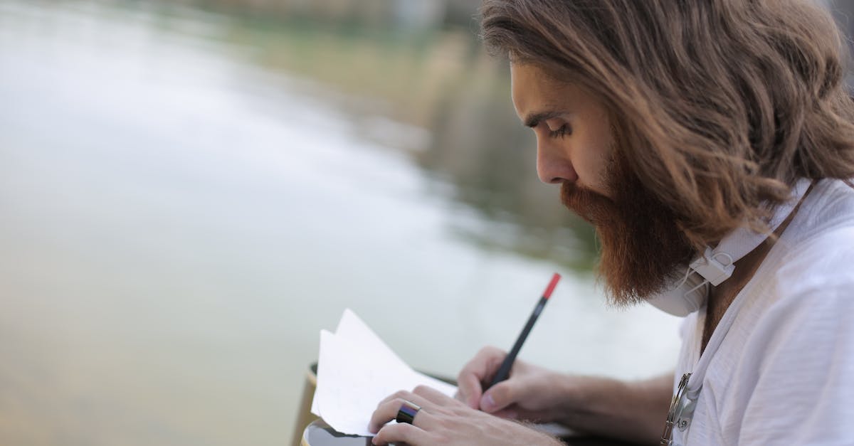 man-in-white-shirt-writing-on-a-paper-8025372