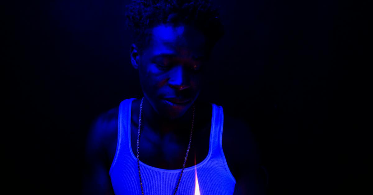man-in-white-tank-top-lighting-a-cigarette-2775224