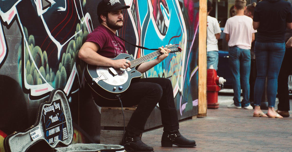 man-playing-black-cutaway-guitar-8223115