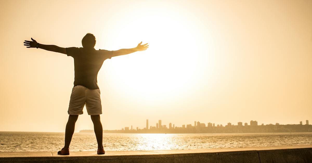 man-standing-on-ledge-while-spreading-arms-2460055