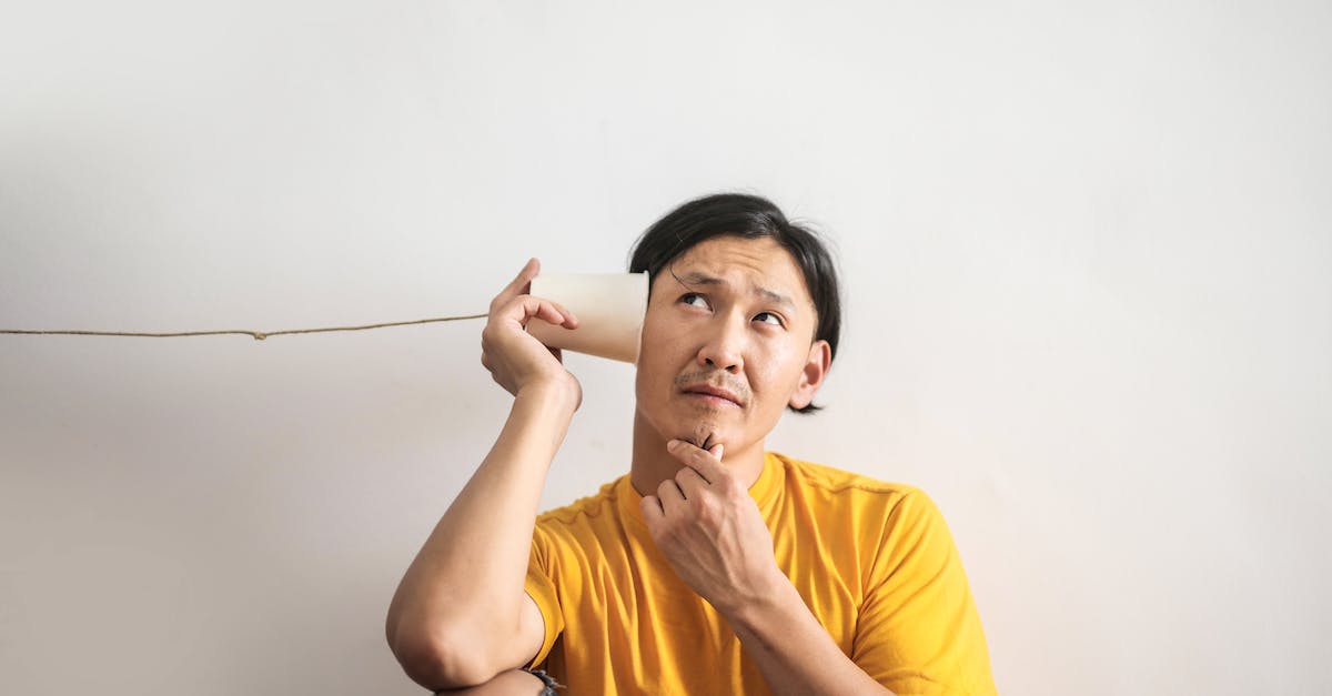 pensive-ethnic-man-listening-to-answer-in-paper-cup-phone-5137345