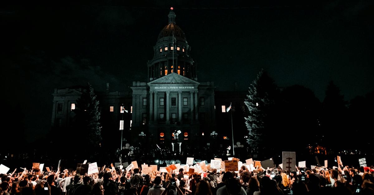 people-rallying-in-front-of-white-building-during-nightime-2446802