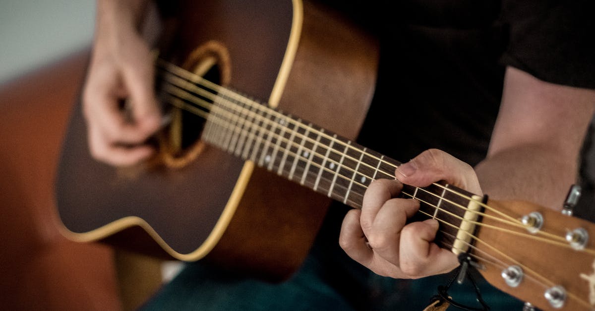 person-playing-brown-guitar-4328567