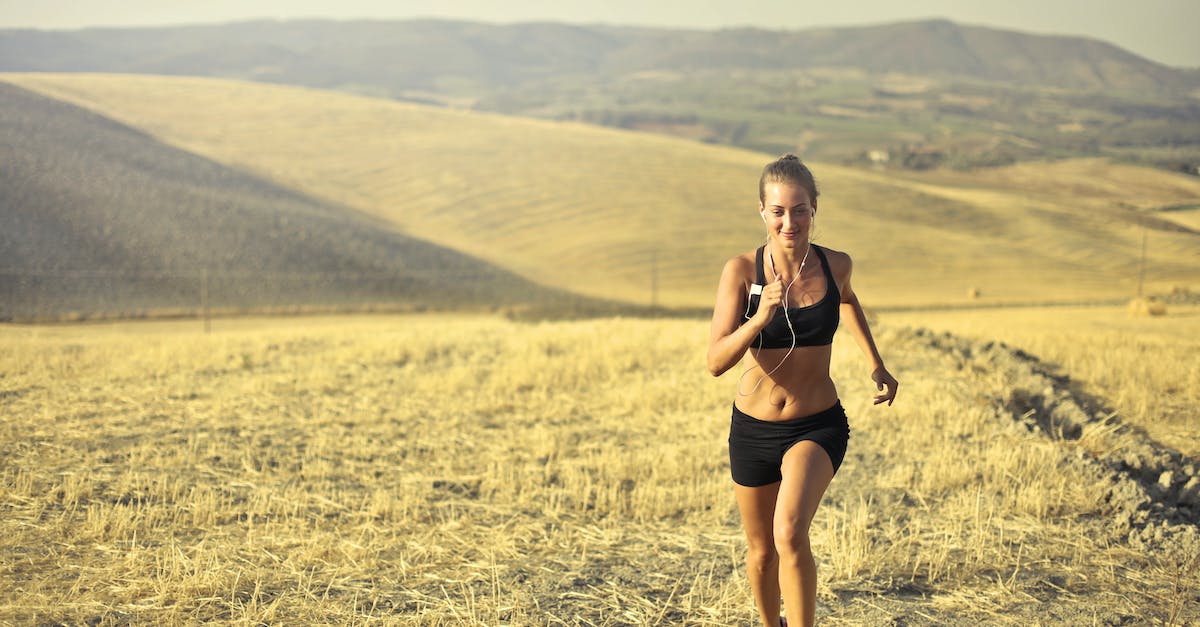 powerful-young-female-athlete-in-activewear-running-along-hill-on-background-of-mountainous-landscap-4335487