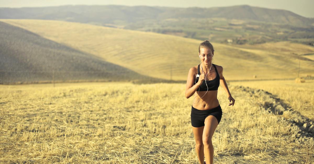 powerful-young-female-athlete-in-activewear-running-along-hill-on-background-of-mountainous-landscap-5664895