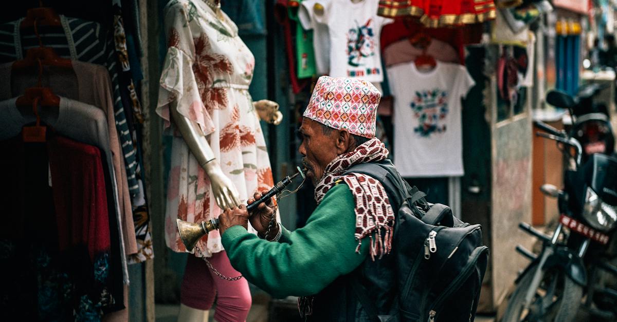 side-view-of-anonymous-mature-ethnic-male-artist-with-backpack-playing-musical-instrument-while-stan-8818298