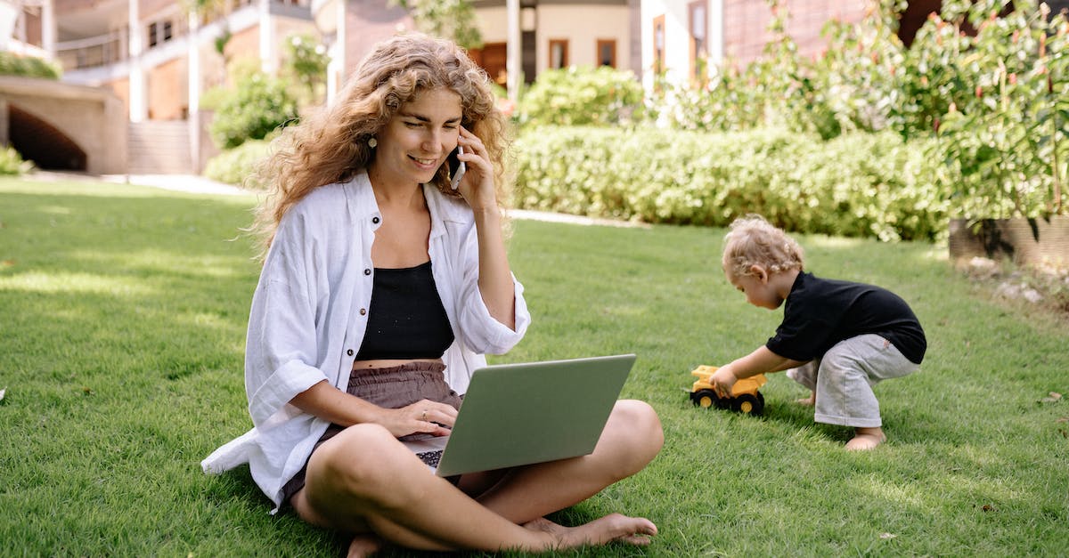 smiling-blonde-woman-sitting-with-laptop-in-garden-1447887