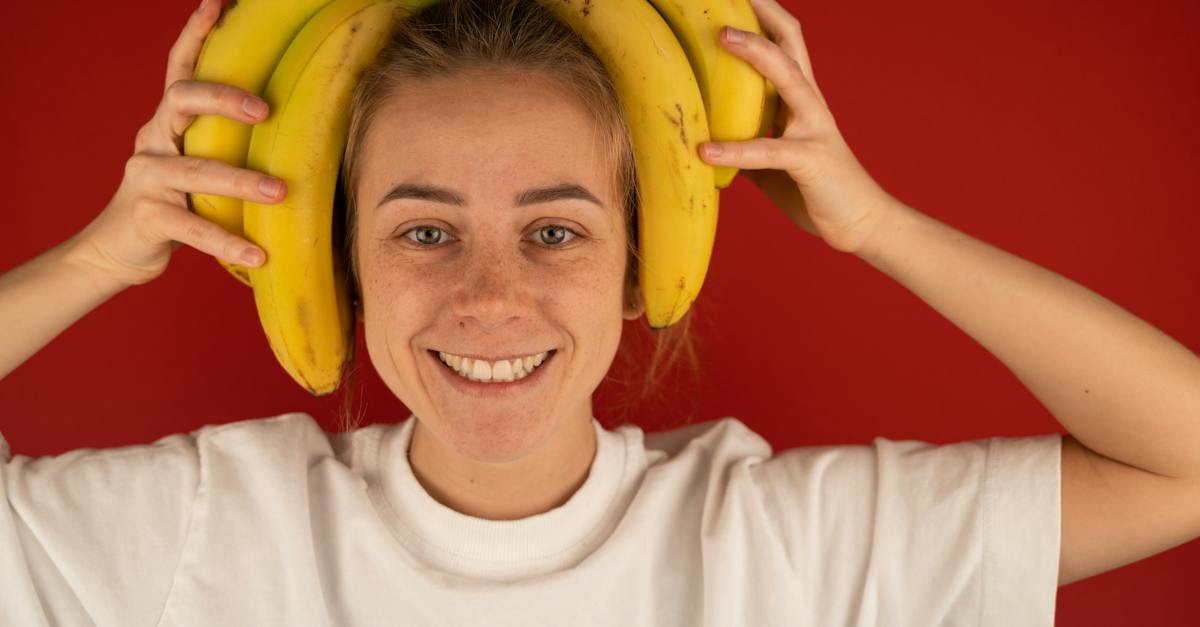 smiling-woman-with-bunch-of-fresh-bananas-on-head-5373961