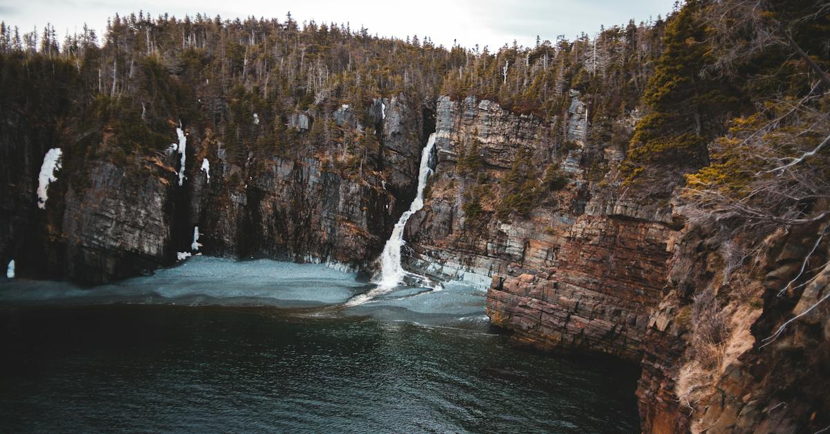 spectacular-scenery-of-rough-mountain-formation-with-rapid-splashing-waterfall-flowing-into-calm-lak-4847227
