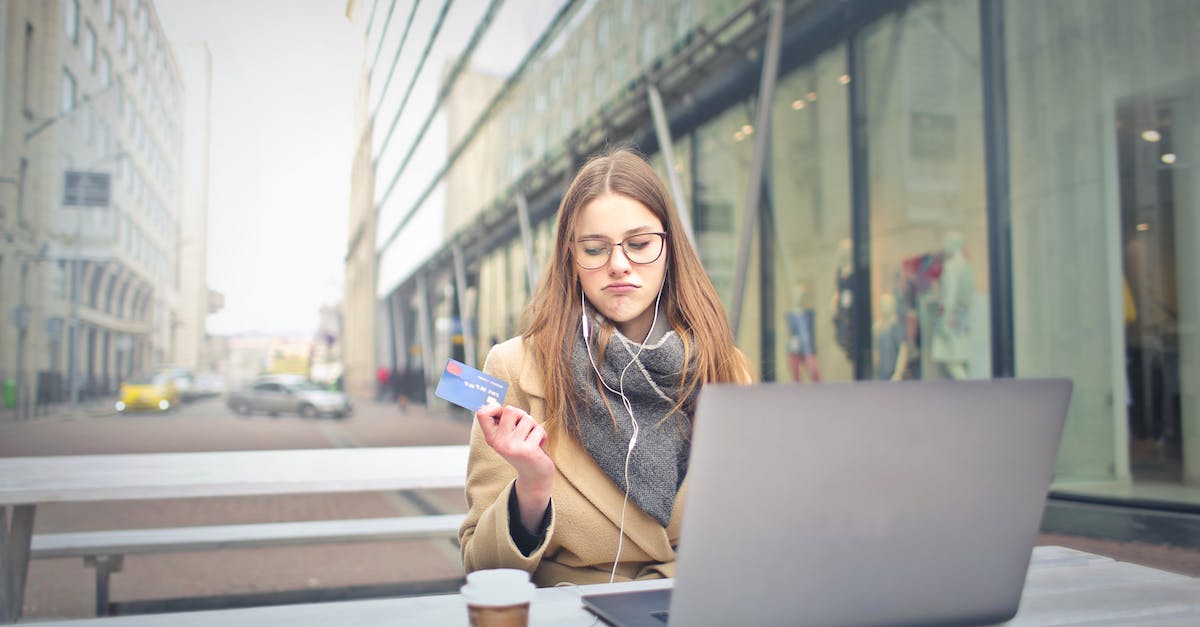 woman-in-brown-coat-holding-a-bank-card-5120812