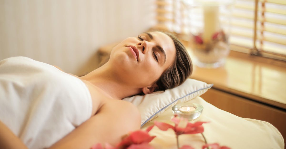 woman-in-wrapped-in-white-towel-lying-on-bed-with-eyes-closed-7580058