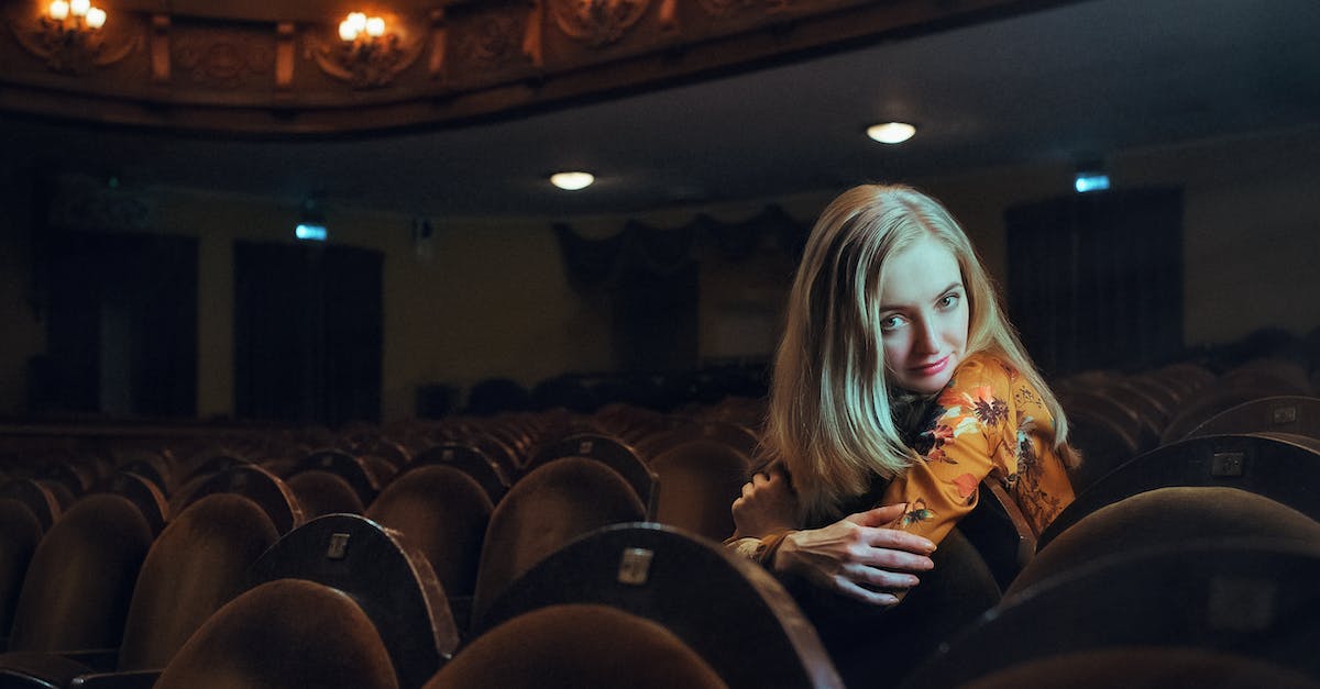 woman-sitting-down-on-theater-chair-4485854