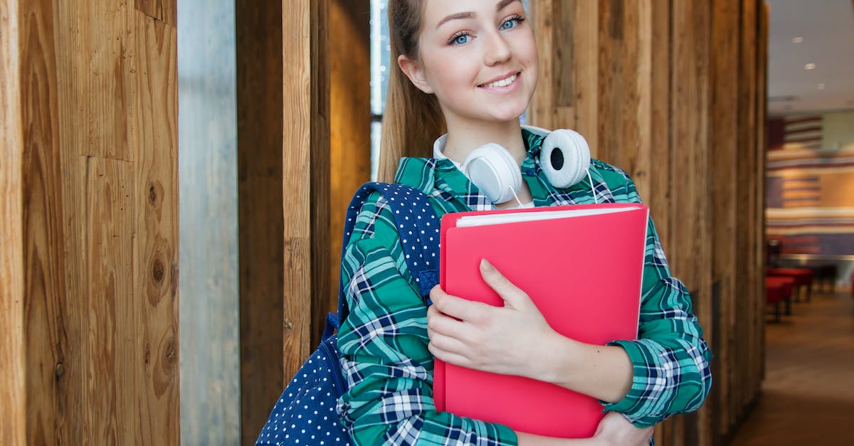 woman-standing-in-hallway-while-holding-book-2030945